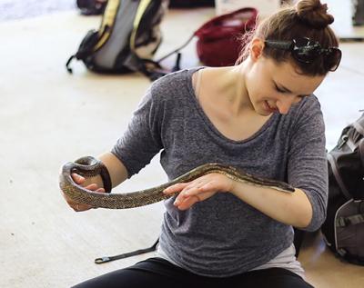 herp class student holding snake in herpetology field trip classroom